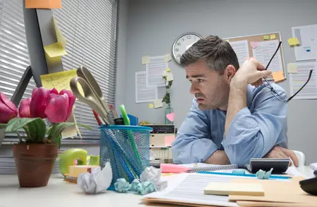 Stressed office man with too much paperwork in dire need of digital transformation